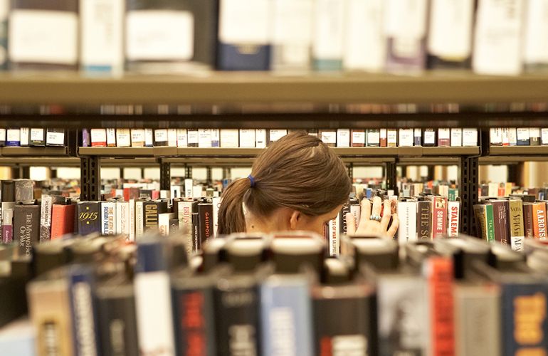 Woman browsing a bookshelf at State Library Victoria
