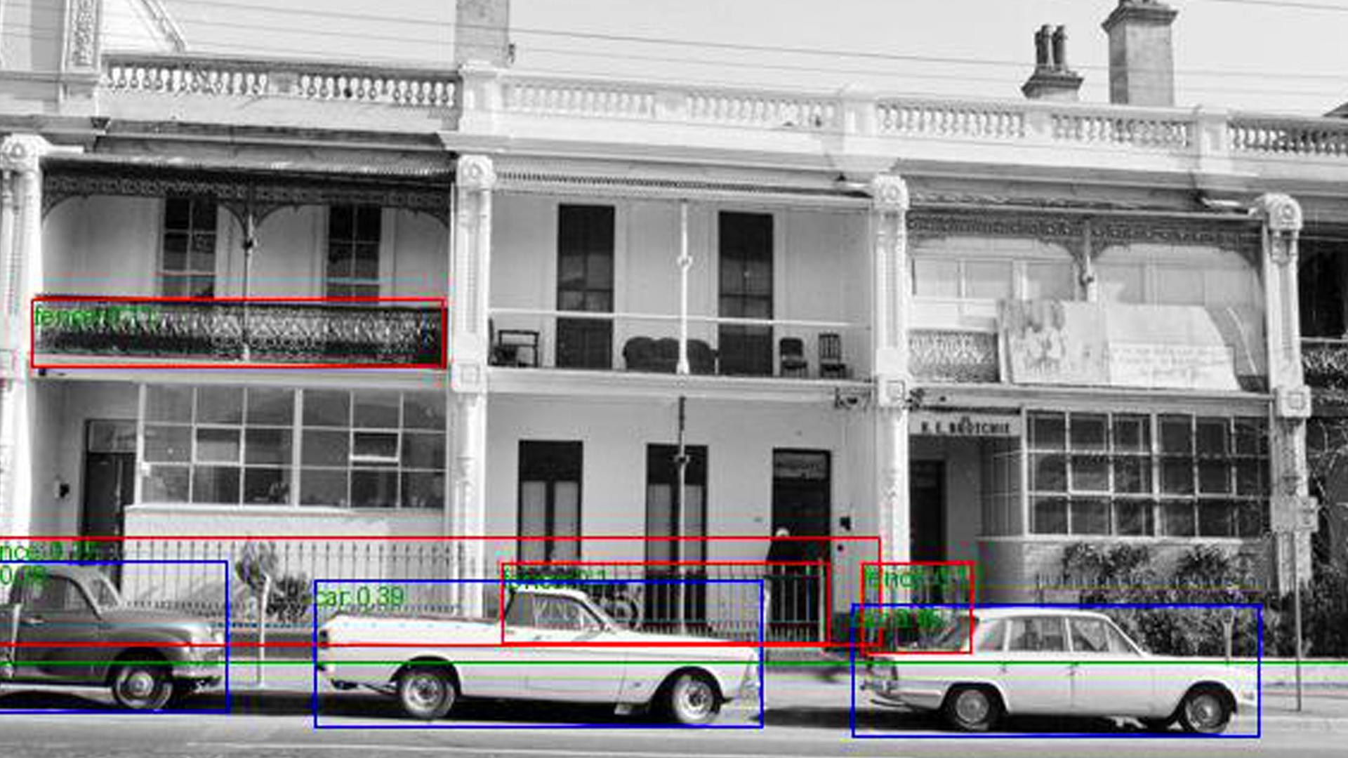 Black and white photograph of a streetscape, depicting a row of terraced houses with cars over them. There are colourful boxes that have been added to the image.