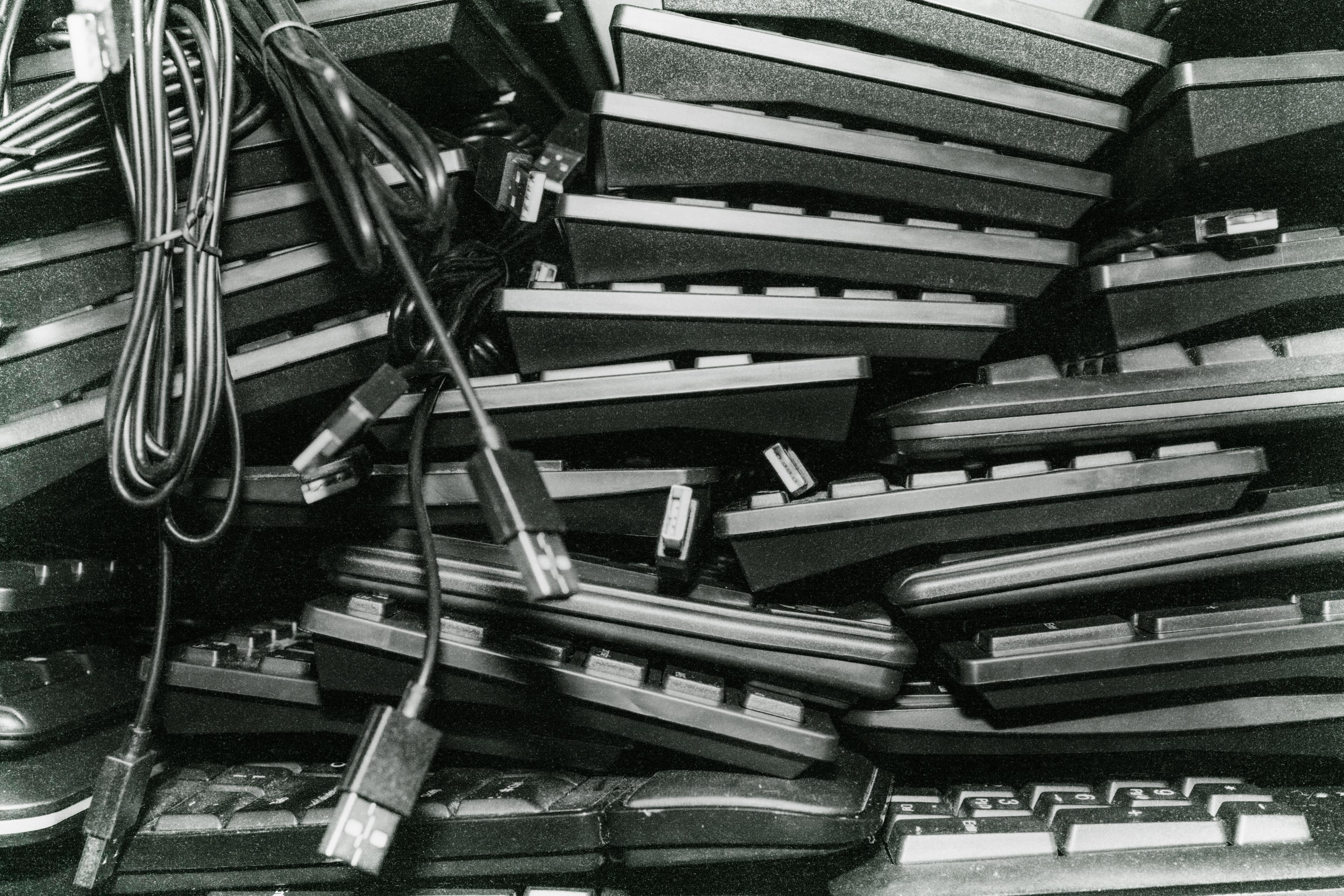 A stack of computer keyboards photographed from the side.