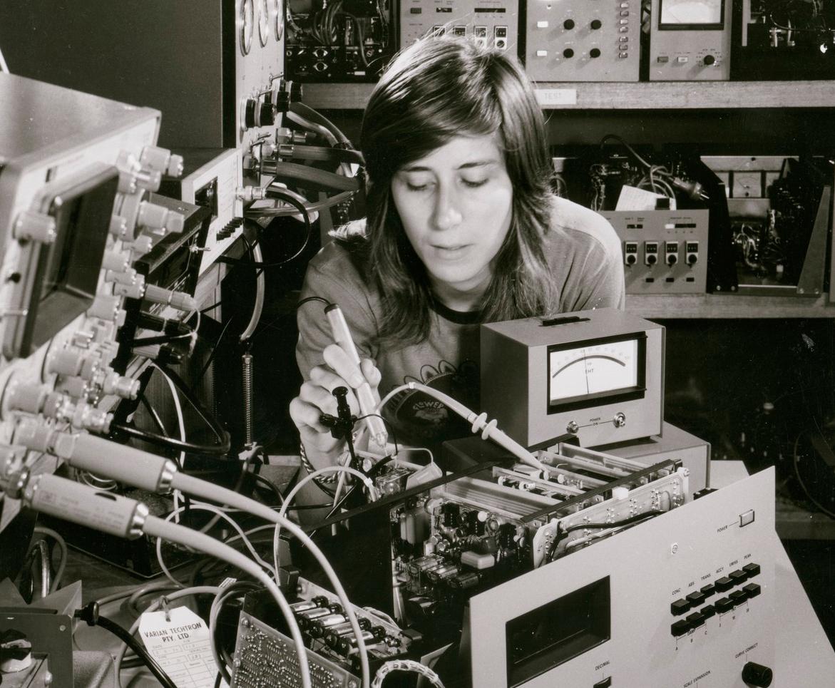 Woman technician working on a bundle of wires and devices