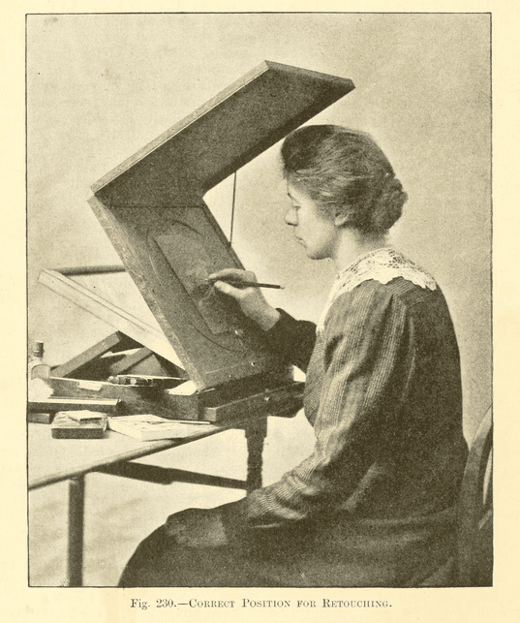 A sepia illustration of a woman from the 1800s working at a slanted retouching desk