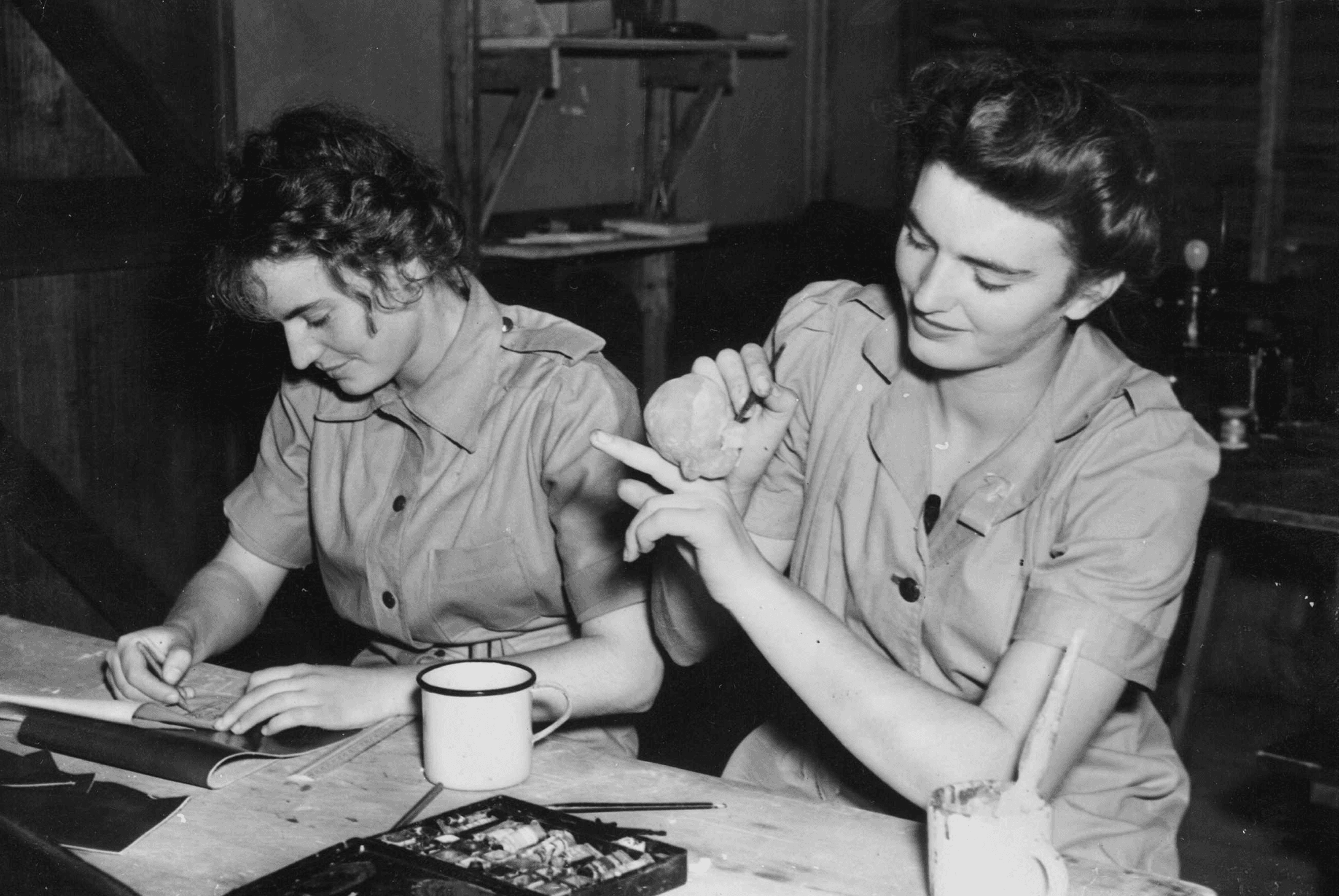 A black and white photo of women at a craft station